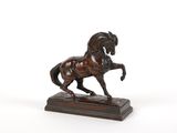 statue en bronze d'un cheval sur un socle en bois sur fond blanc