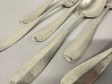 five silver spoons and two silver spoons on a table