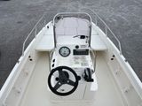 a white boat with a steering wheel and a clock on it