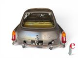 a silver car with a bed in the back of it