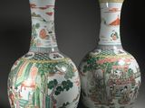 une paire de vases chinois ornés de scènes asiatiques, posés sur une table
