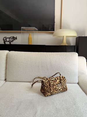 a white couch with a leopard print purse on top of it