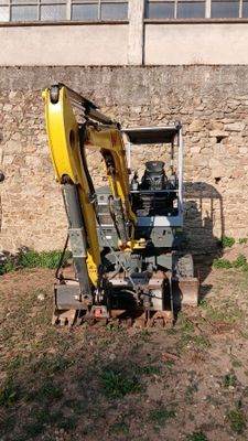 une pelleteuse jaune qui est à l'arrêt dans la terre