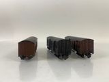 three toy train cars sitting side by side on a white surface