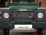 an image of a green land rover parked in front of a brick building
