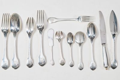 un grand nombre de cuillères et de fourchettes en argent disposées sur une table