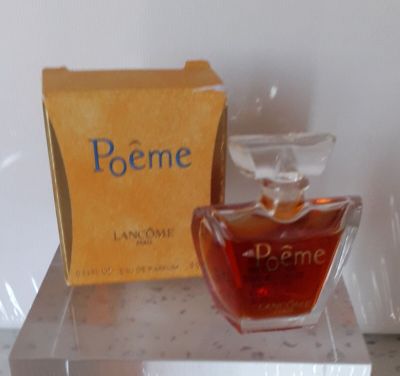 un flacon de parfum posé sur une table à côté d'une boîte de parfum