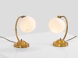 a pair of brass table lamps on a white surface