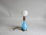 une lampe bleue et blanche surmontée d'un abat-jour en verre