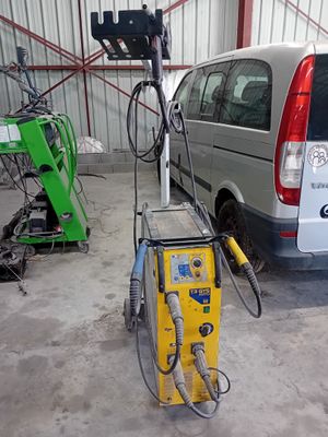 une camionnette garée dans un garage, avec une machine posée au sol