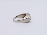 a close up of a ring on a white surface with a diamond