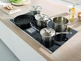 des casseroles et des poêles sont posées sur la plaque de cuisson dans une cuisine