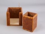 two small wooden boxes are sitting side by side on a white surface