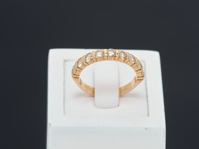un gros plan d'une bague en or posée sur une boîte blanche