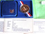 a blue box with a silver medal and a red, white, and blue ribbon