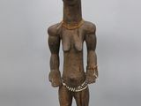 une statue en bois représentant un homme avec une chaîne autour du cou