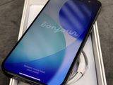 une image représentant un téléphone noir posé sur une boîte blanche