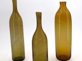 three brown bottles sitting next to each other on a white surface