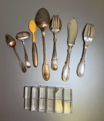 a lot of silverware on a table with spoons and forks