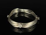 a close up of a silver bracelet on a black surface