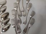 many forks and spoons laid out on a table