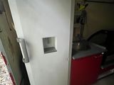 a white refrigerator in a garage next to a red cabinet