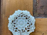 a white flower brooch on a wooden table