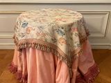 a small table with a pink table cloth on top of it
