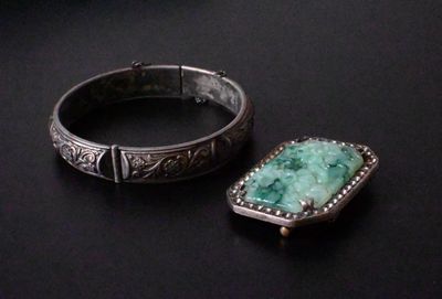 paire de bracelets en argent et en jade sur un fond noir