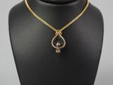 a black and gold necklace on a mannequin neck