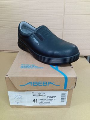 une image représentant une paire de chaussures noires posée sur une boîte