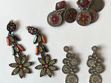 three pairs of earrings and a pair of earrings are sitting on a white surface