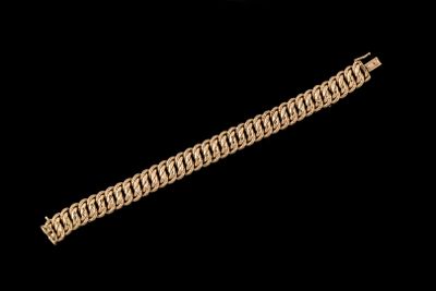 gros plan d'un bracelet en or sur fond noir
