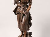 an antique bronze statue of a woman holding a baby