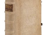 un vieux livre posé sur une table blanche à côté d'un mur blanc