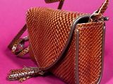 an image of a small brown purse on a pink background