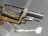 a person holding a small revolver in their hand