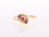 a close up of a gold ring with two ruby stones