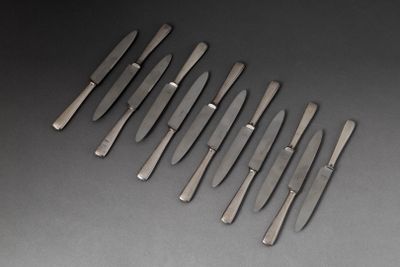 six couteaux sont alignés les uns à côté des autres sur une surface noire