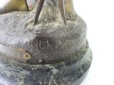 a bronze statue of a woman sitting on top of a rock