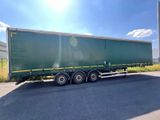 a green semi trailer parked in a parking lot