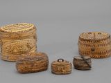 trois petites boîtes en osier avec couvercles et poignées, posées sur une surface grise