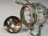 a glass jar with a silver lid and a metal handle