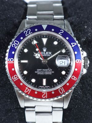 une montre Rolex avec une lunette rouge, blanche et bleue