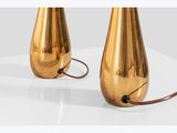 pair of brass table lamps with a black cord on a white surface
