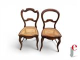 pair of antique chairs with cane back and cane seat on white background