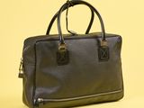 sac à main en cuir noir sur fond jaune, avec un espace réservé au texte