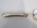 a silver spoon with a handle on a white surface
