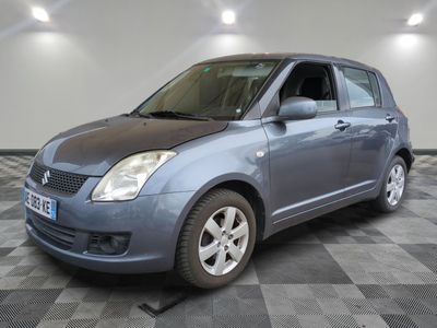 la photo d'une petite voiture bleue sur un sol en damier