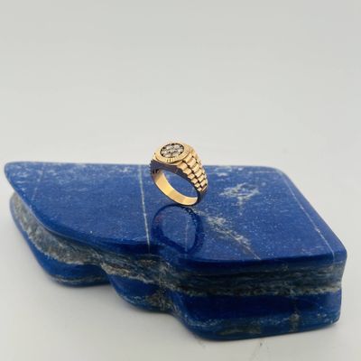 a close up of a gold ring on a blue stone